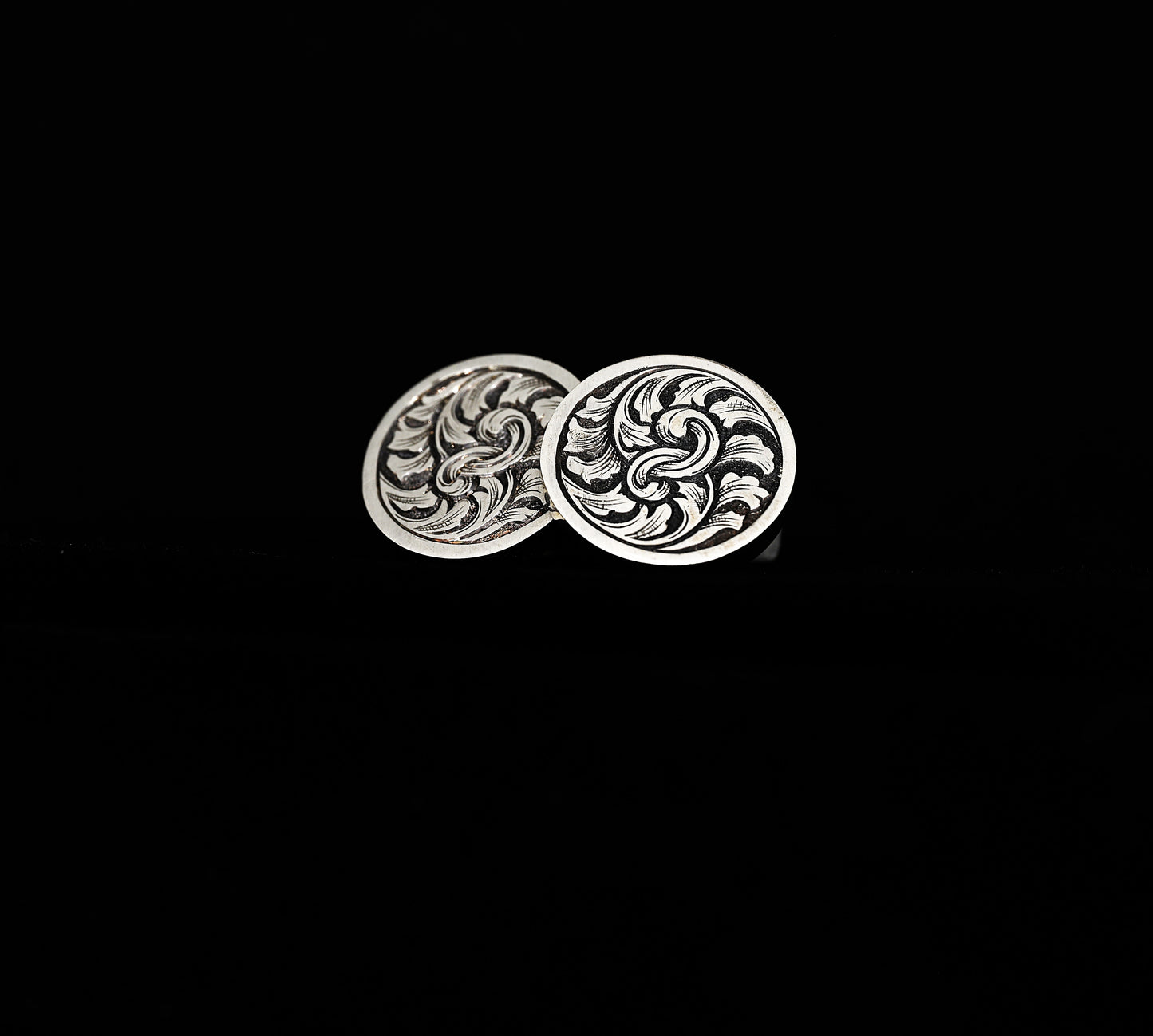 A pair of hand-crafted silver cufflinks with traditionally hand-engraved acanthus leaf design