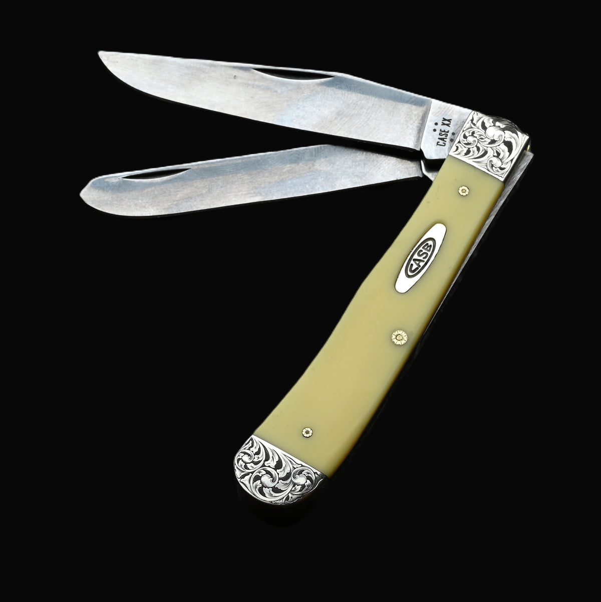 Case yellow synthetic large trapper folding knife featuring hand-engraved ornate silver-toned metal bolsters and pins.