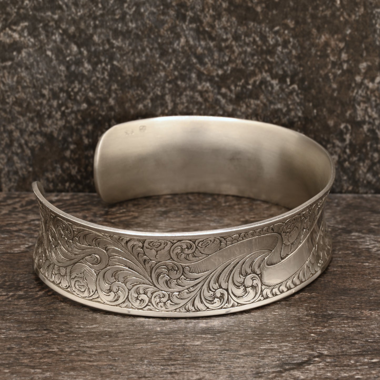 Sterling silver cuff bracelet with intricate hand‑engraved scrollwork and floral design