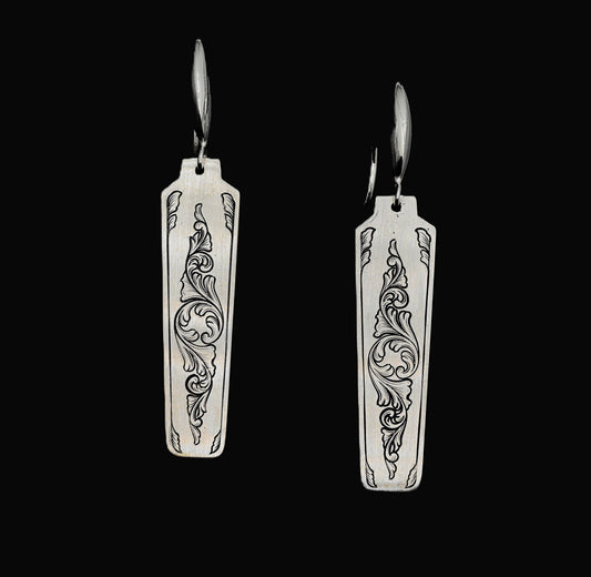 A pair of hand-crafted sterling silver statement earrings with hand-engraved acanthus patterns.