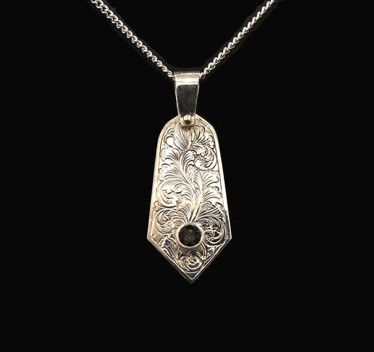 A sterling silver pendant with hand-engraved acanthus leaf design and a green tourmaline gemstone
