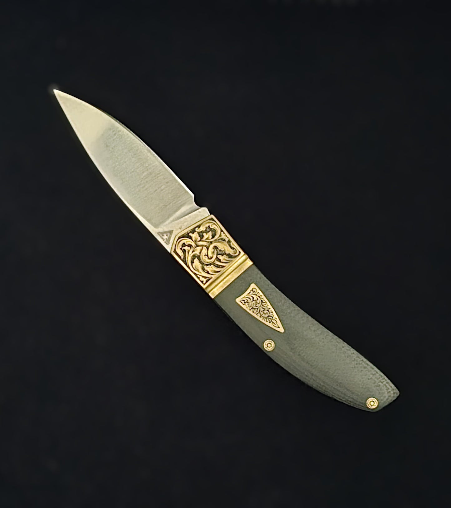 Hand‑engraved folding Begg knife featuring detailed scrollwork and textured handle accents