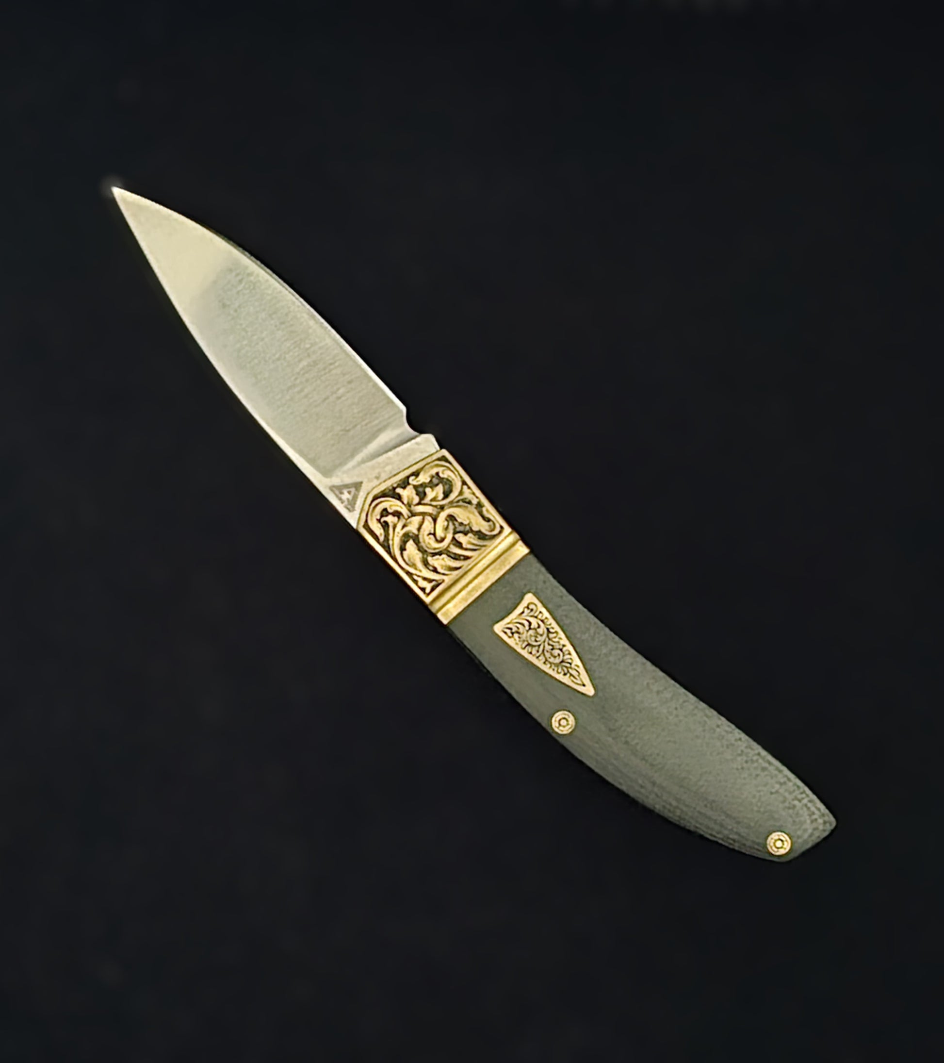 Hand‑engraved folding Begg knife featuring detailed scrollwork and textured handle accents