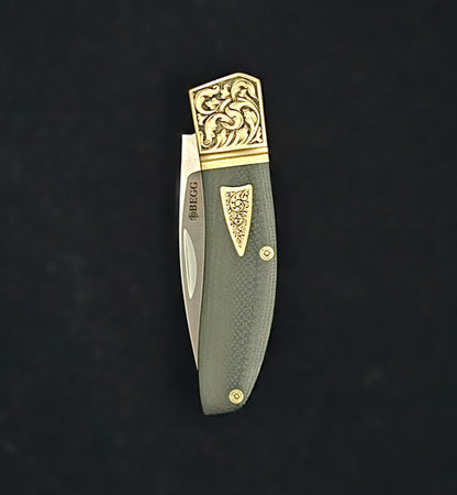 Hand‑engraved folding Begg knife in closed position featuring detailed scrollwork and textured handle accents