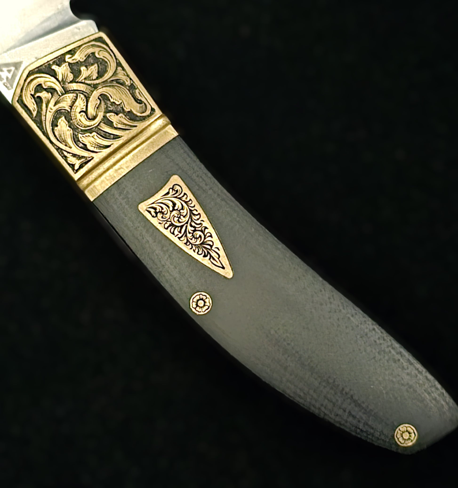 Hand‑engraved folding Begg knife featuring detailed scrollwork and textured handle accents