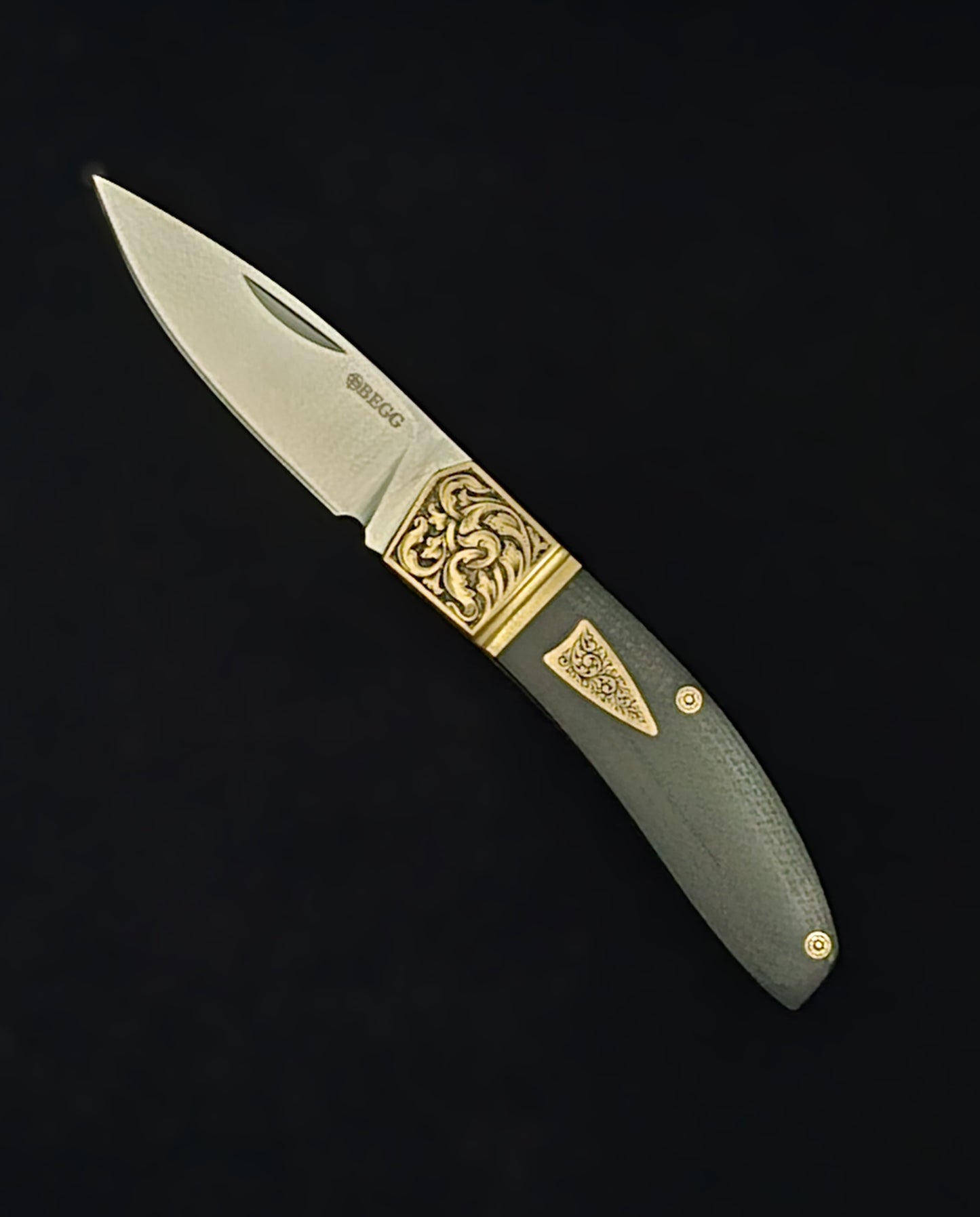 Hand‑engraved folding Begg knife featuring detailed scrollwork and textured handle accents