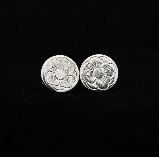 A pair of hand-engraved sterling silver stud earrings with a floral design