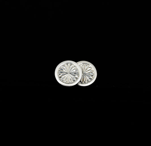 A pair of hand-engraved sterling silver stud earrings with a floral pattern