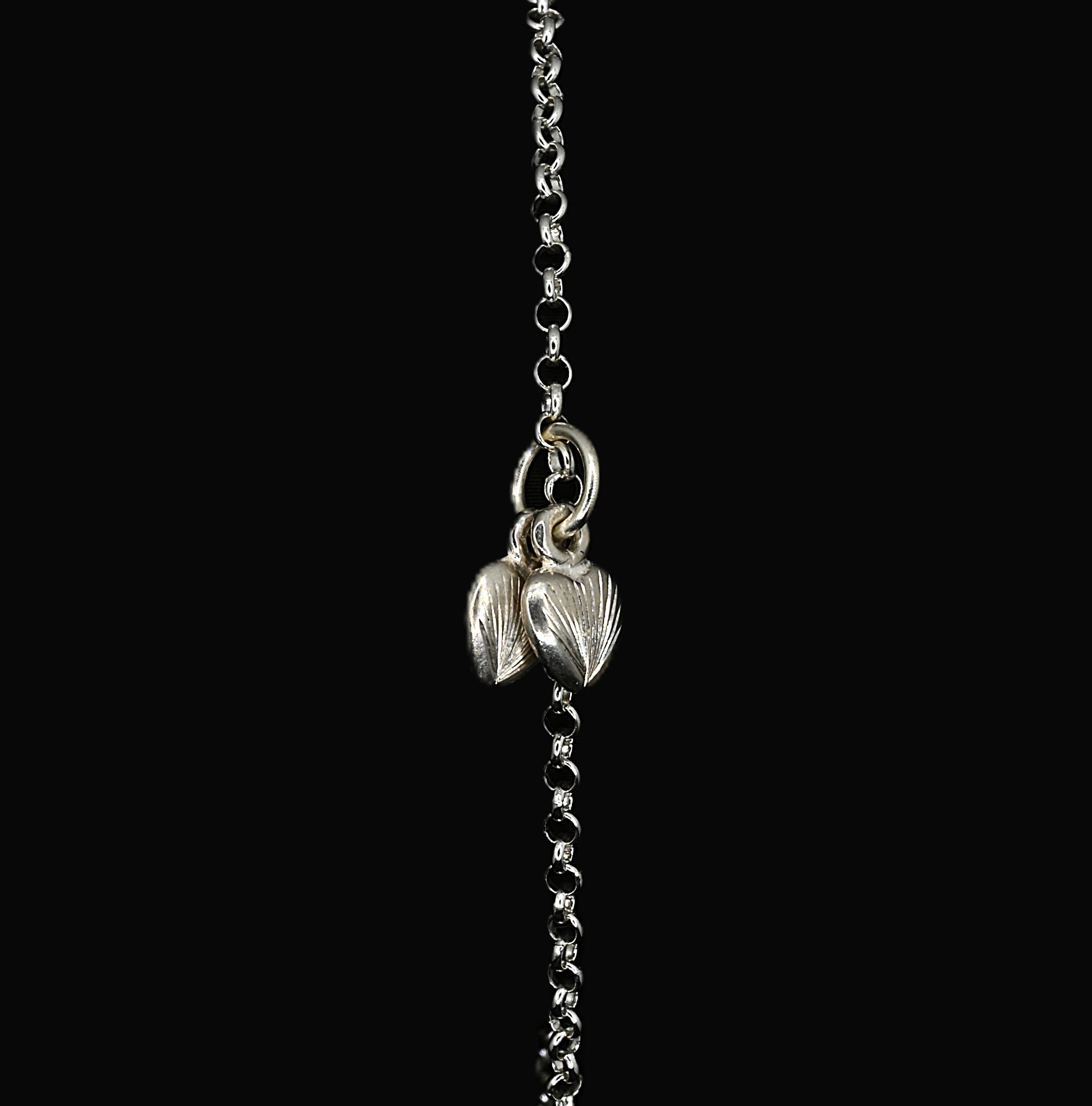 A sterling silver bracelet with a hand-engraved twin hearts charm