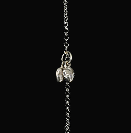 A sterling silver bracelet with a hand-engraved twin hearts charm