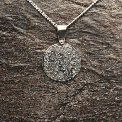 Hand-engraved round sterling silver pendant, featuring traditional acanthus design