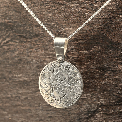 Hand-engraved round sterling silver pendant, featuring traditional acanthus design