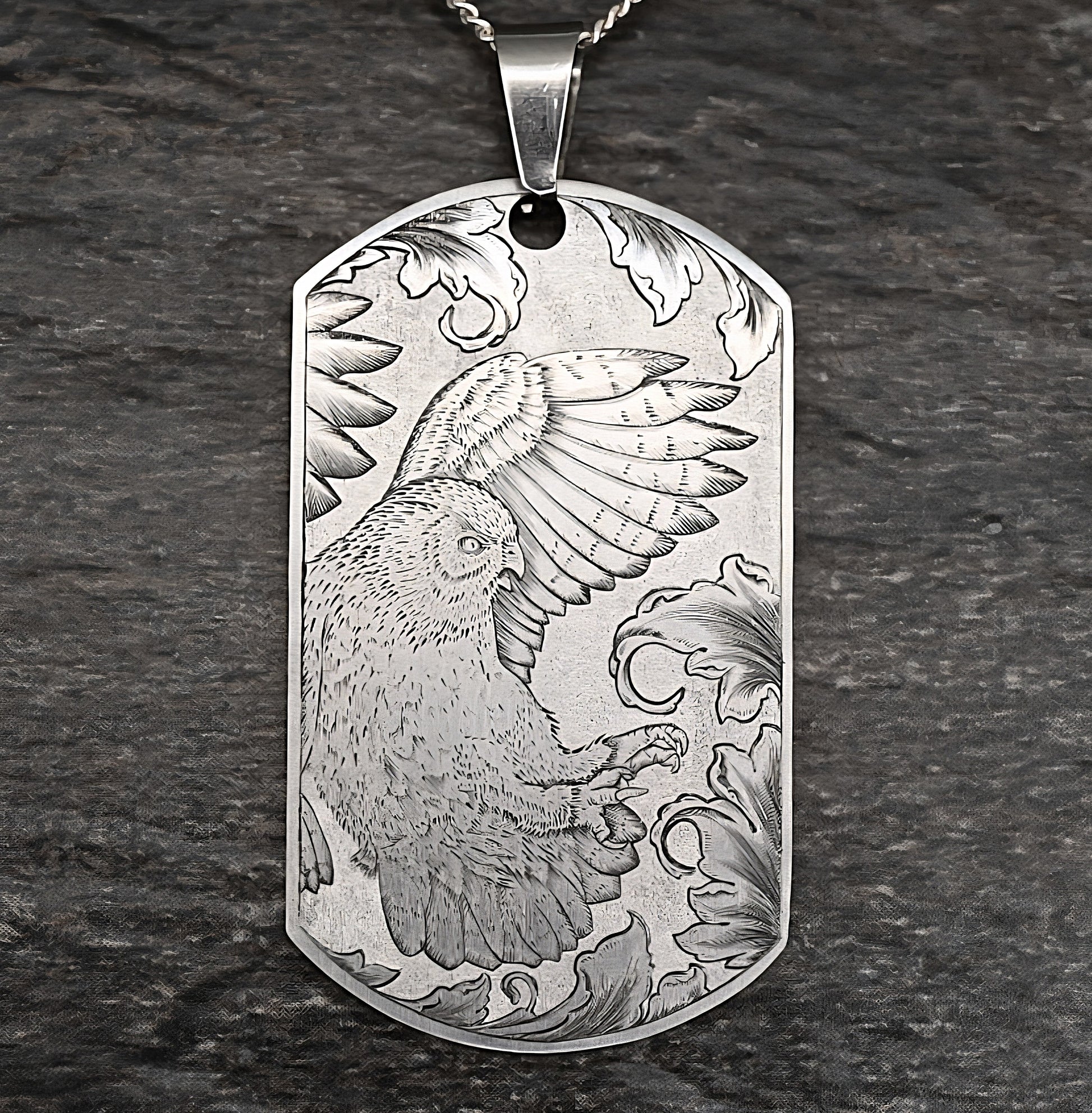 Hand‑engraved titanium owl pendant, dog‑tag style, featuring an owl diving toward prey.