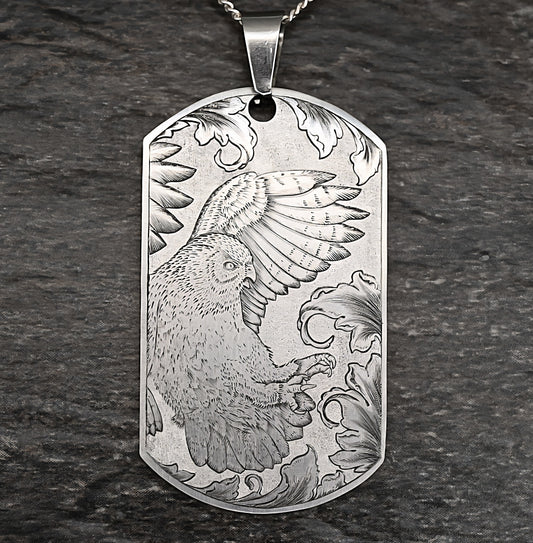 Hand‑engraved titanium owl pendant, dog‑tag style, featuring an owl diving toward prey.