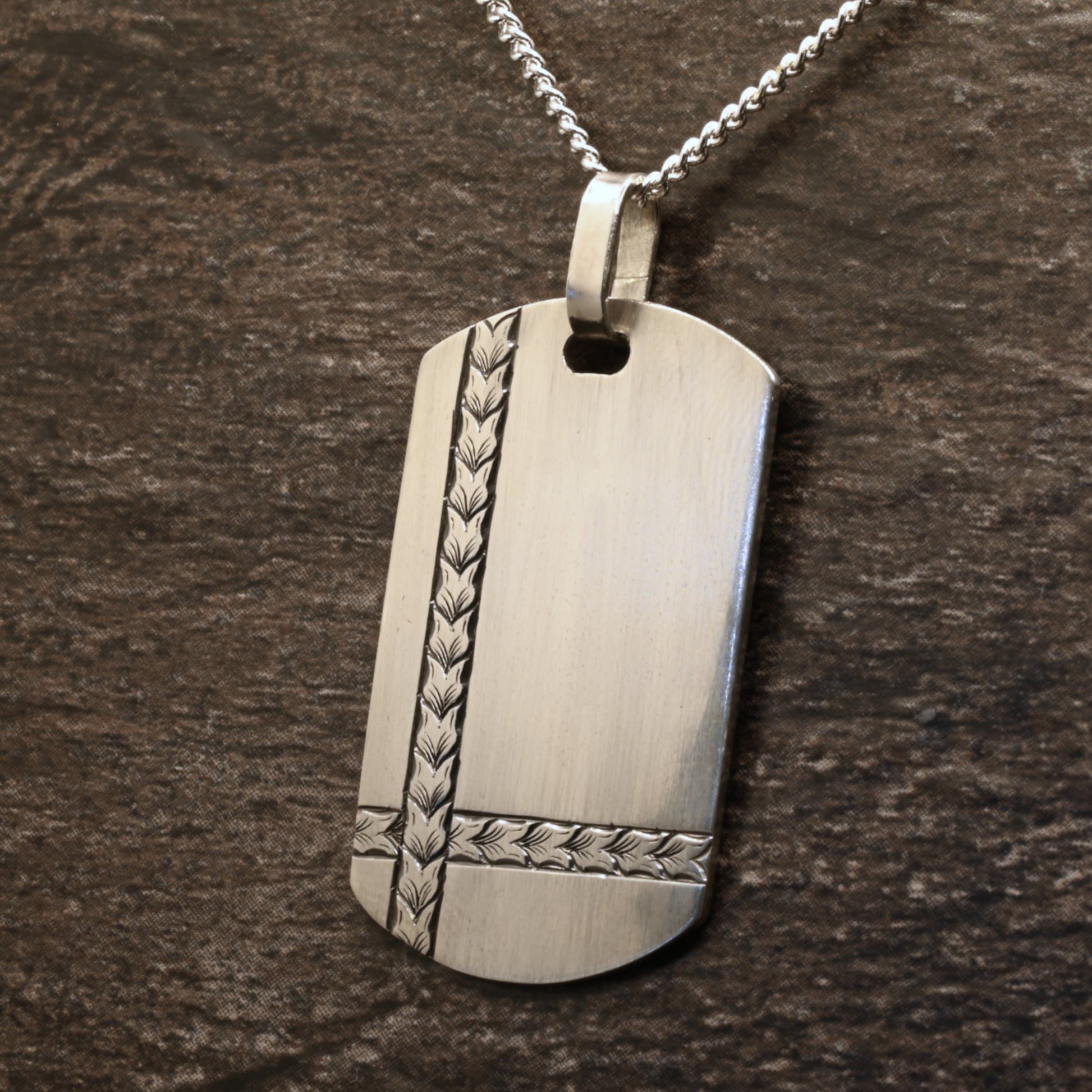 Sterling silver dog‑tag pendant with hand‑engraved intersecting wheat design
