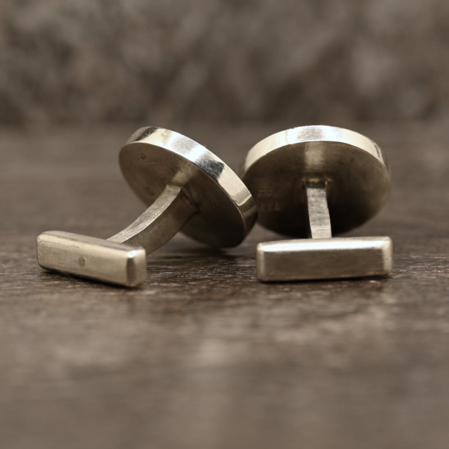 Back view of sterling silver cufflinks with hand‑engraved scrollwork design