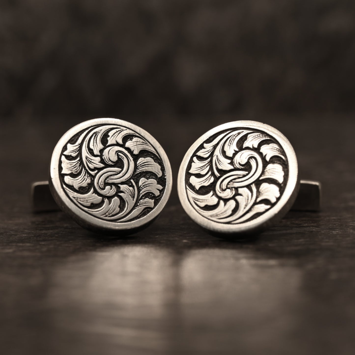 Sterling silver cufflinks with hand‑engraved scrollwork design