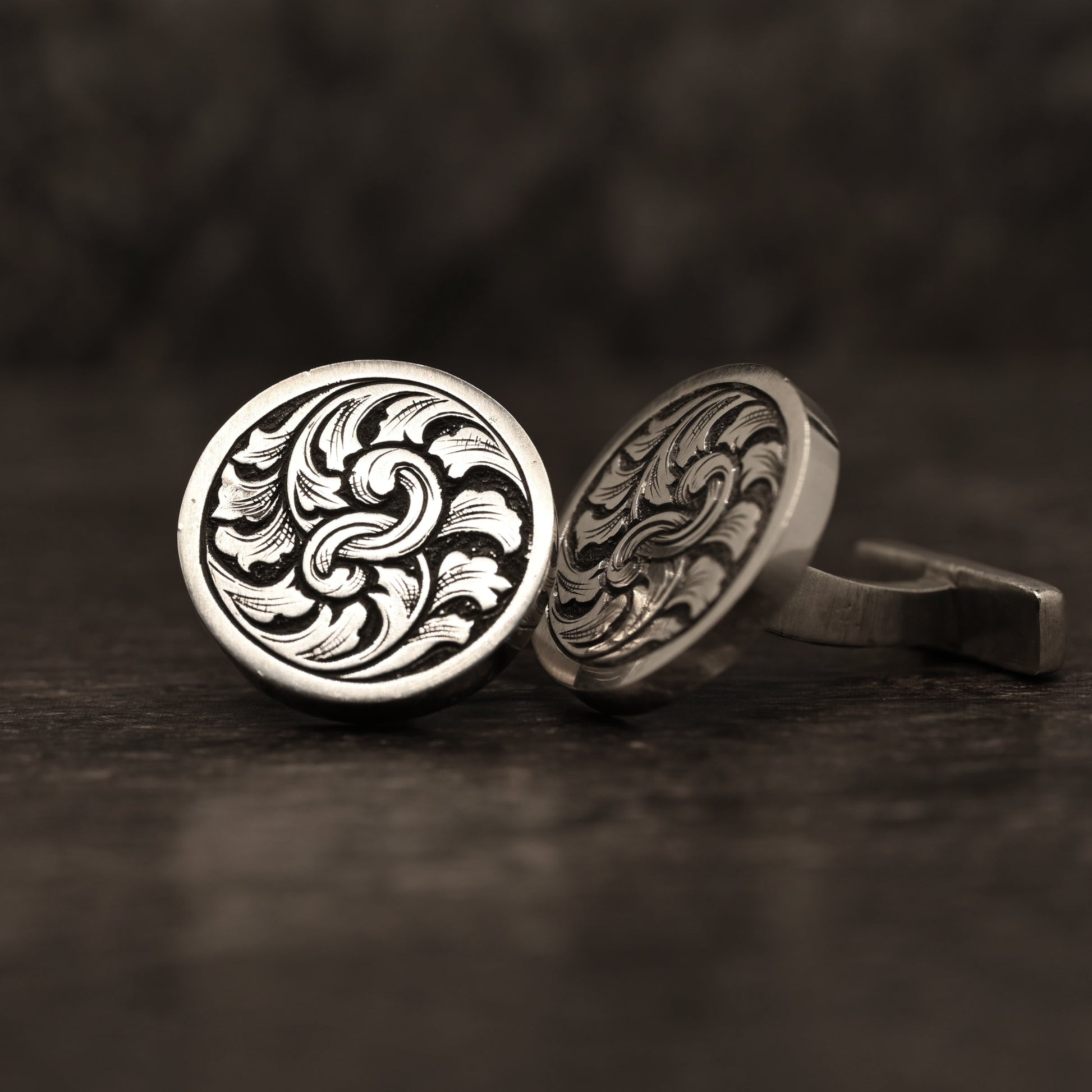 Sterling silver cufflinks with hand‑engraved scrollwork design