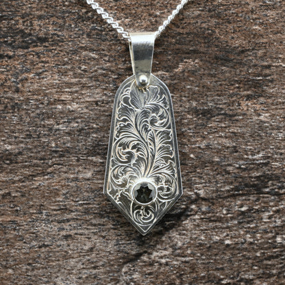 Sterling silver pendant with hand‑engraved acanthus leaf motif and green tourmaline setting