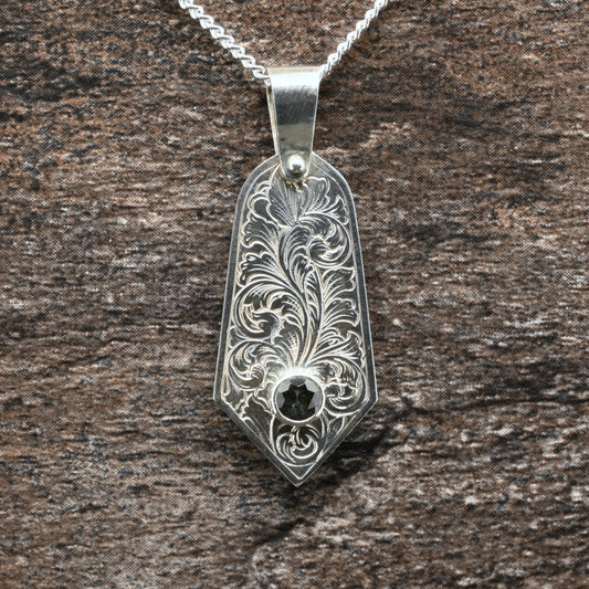 Sterling silver pendant with hand‑engraved acanthus leaf motif and green tourmaline setting