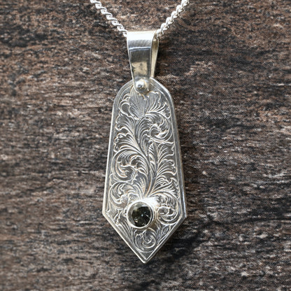 Sterling silver pendant with hand‑engraved acanthus leaf motif and green tourmaline setting