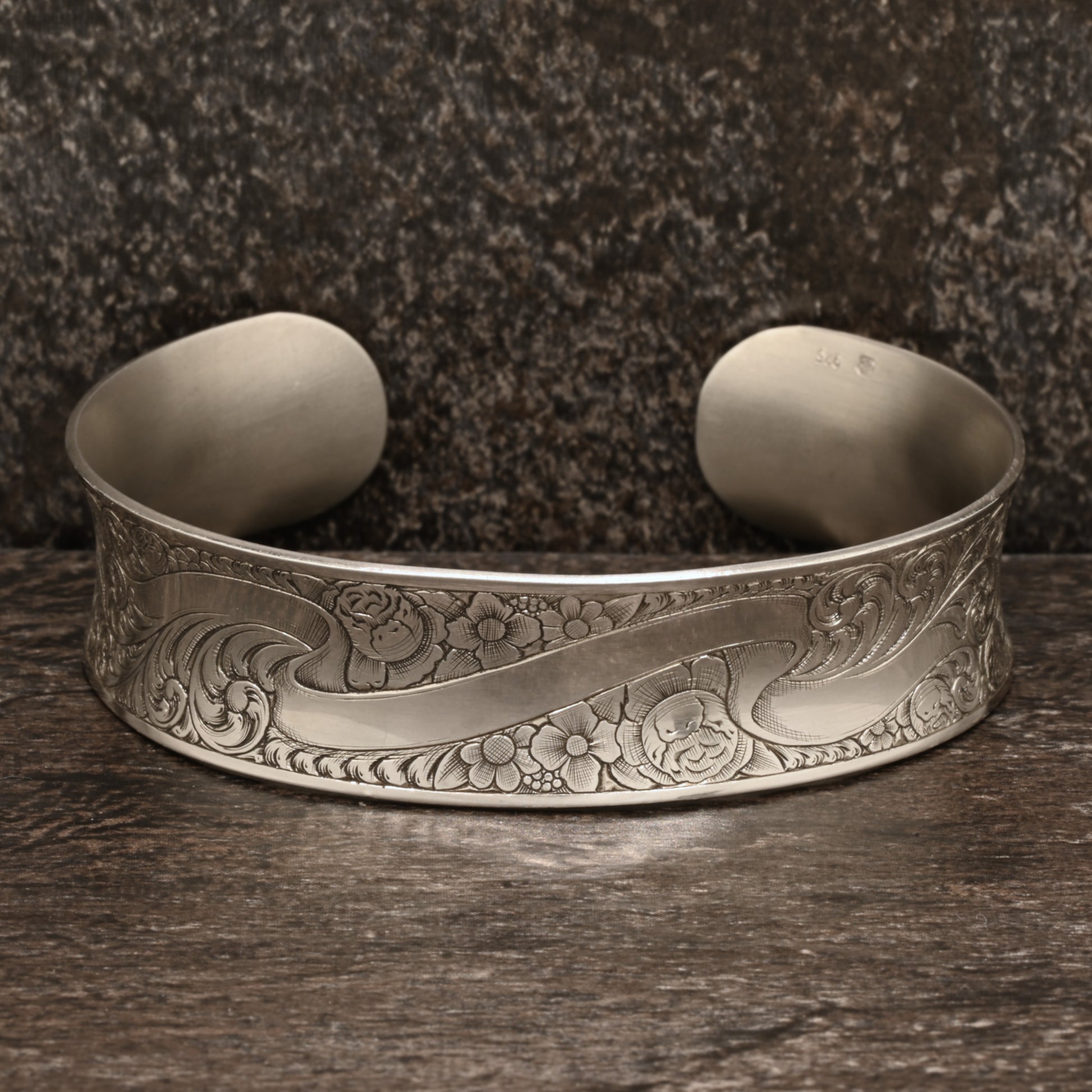 Sterling silver cuff bracelet with intricate hand‑engraved scrollwork and floral design