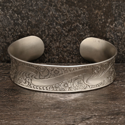 Sterling silver cuff bracelet with intricate hand‑engraved scrollwork and floral design
