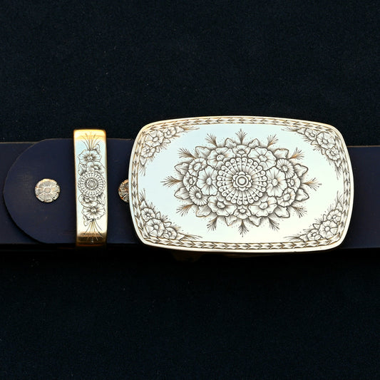 Hand‑engraved brass belt buckle set with floral Western engraving on dark leather.