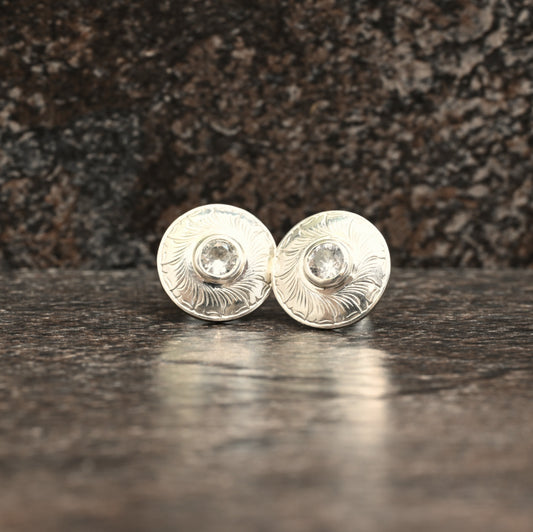 Sterling silver stud earrings with hand‑engraved leaf motif and white sapphire centre
